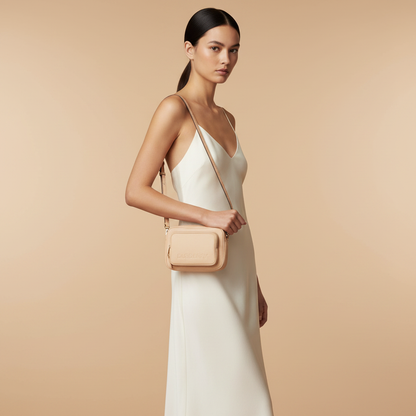 Burberry Small Branded Peach Pink Grainy Leather Camera Crossbody Bag — held by model in studio