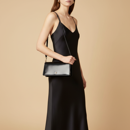 Tory Burch Black Patent Leather Shoulder Bag — held by model in studio