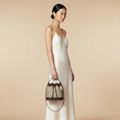 Gucci Venice Mini Beige GG Supreme Bucket Bag — held by model in studio