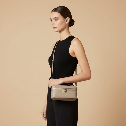 Tory Burch Charlie Gray Quilted Leather Vanity Case — held by model in studio